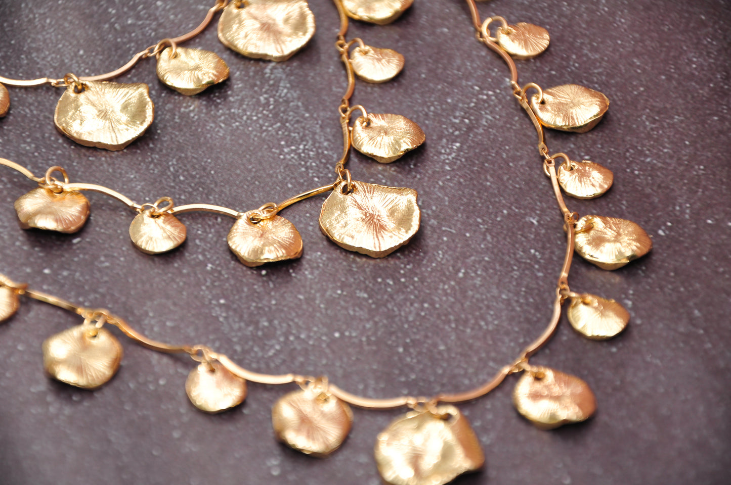 Elegant gold leaf-shaped necklace with layered pendants, crafted from high-quality metal.