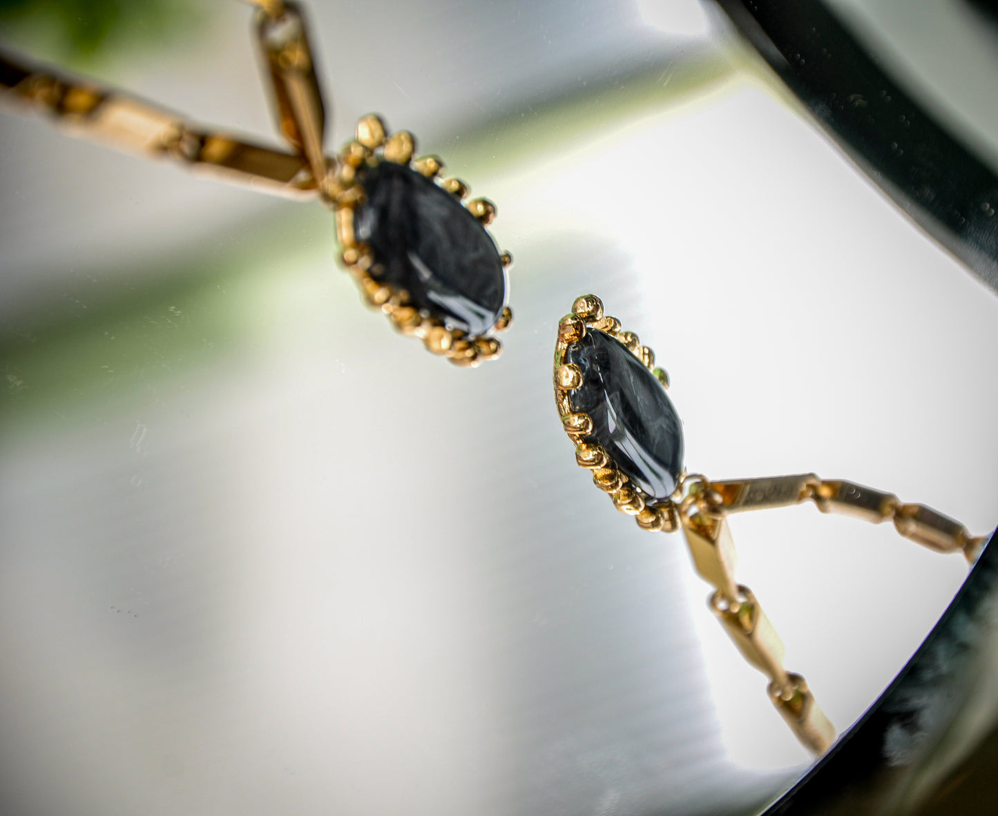 Elegant gold earrings featuring black marquise stones, perfect for formal and casual wear.
