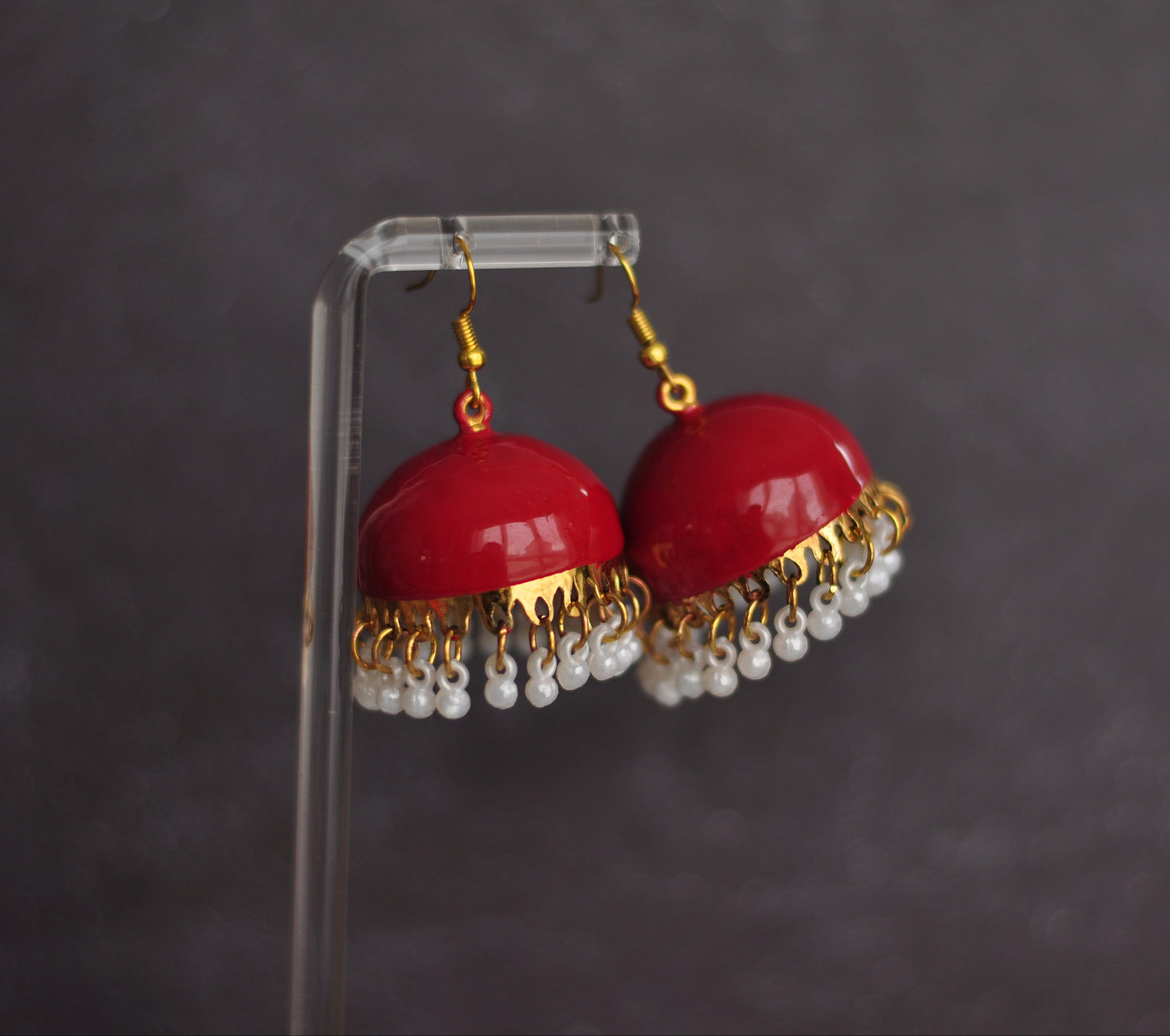 Red dome-shaped earrings with gold accents and white bead fringe, perfect for adding a pop of color.