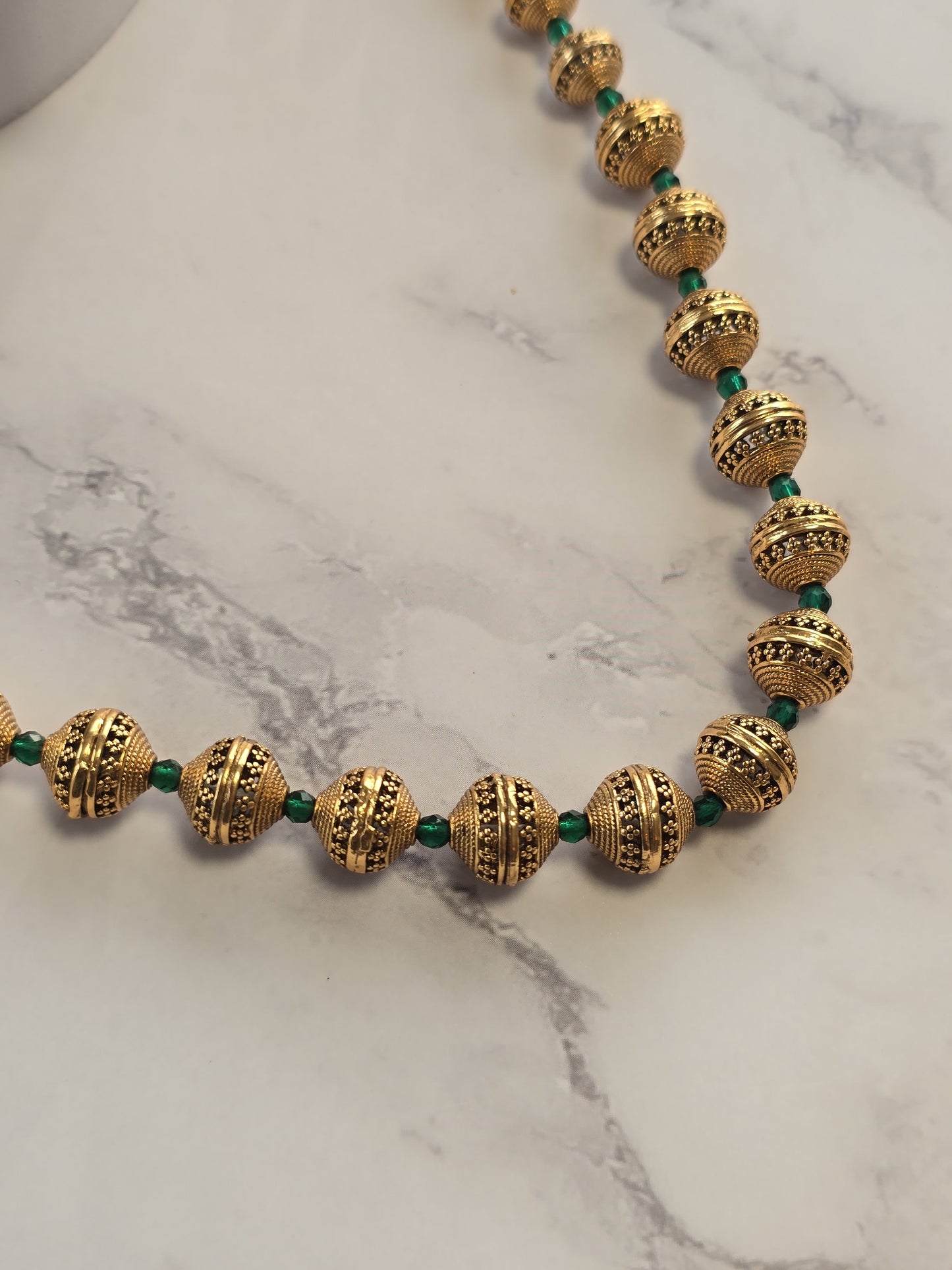 Elegant gold beaded necklace with green accents, featuring intricate patterns and vintage design.