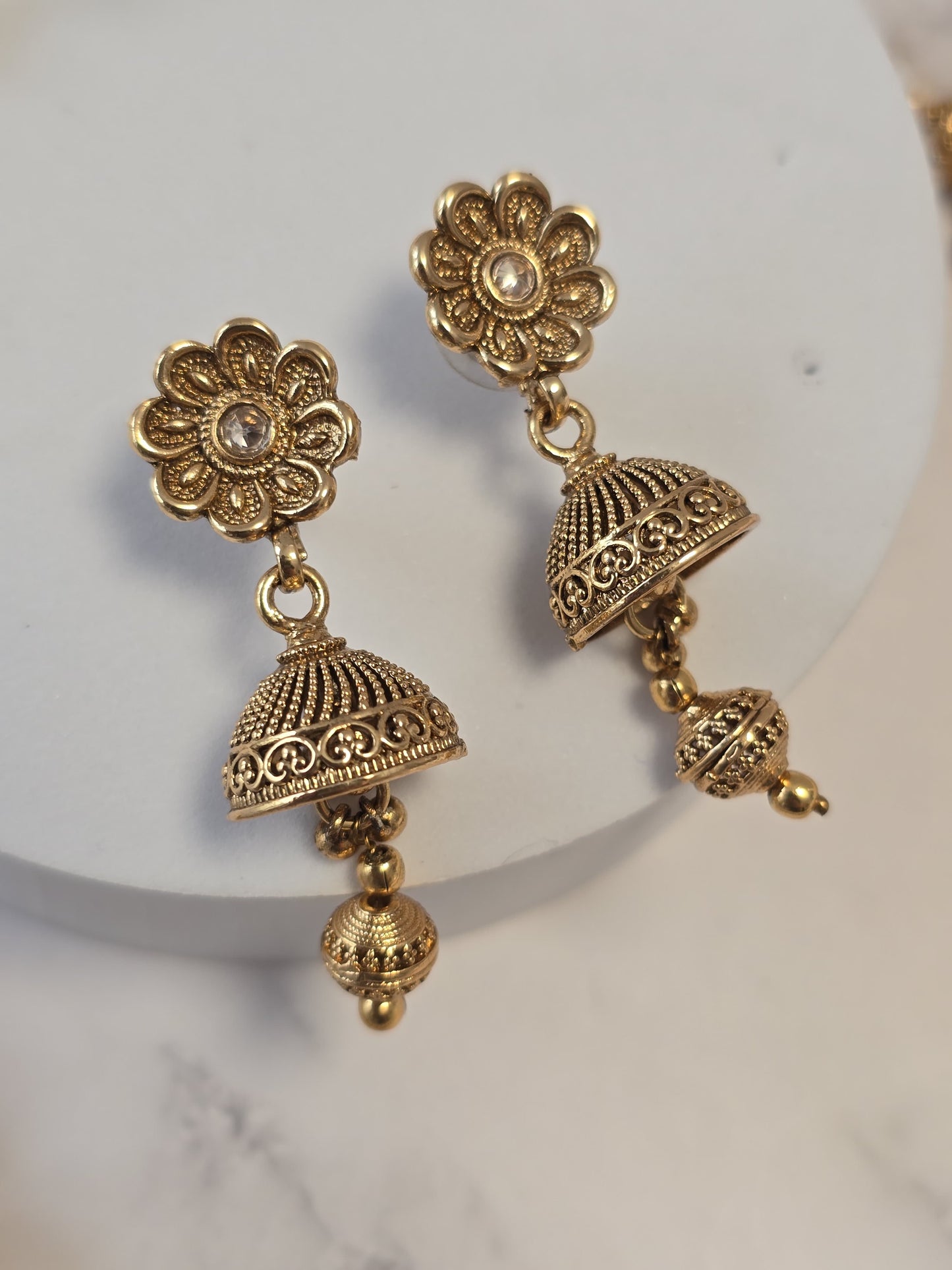 Gold-tone floral dangle earrings with intricate bell design and crystal accents.