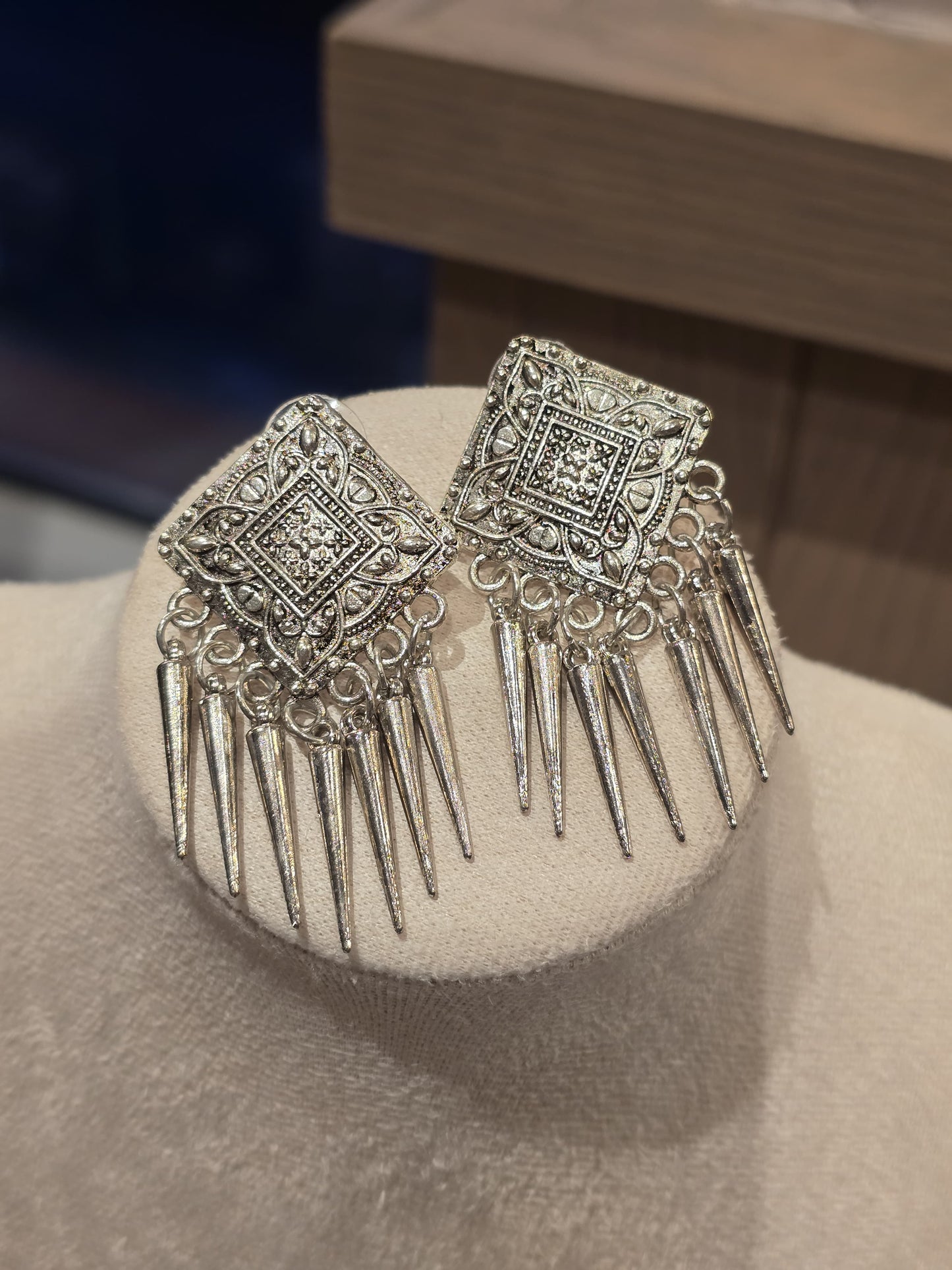 Elegant silver statement earrings with intricate design and pointed accents, perfect for formal occasions.