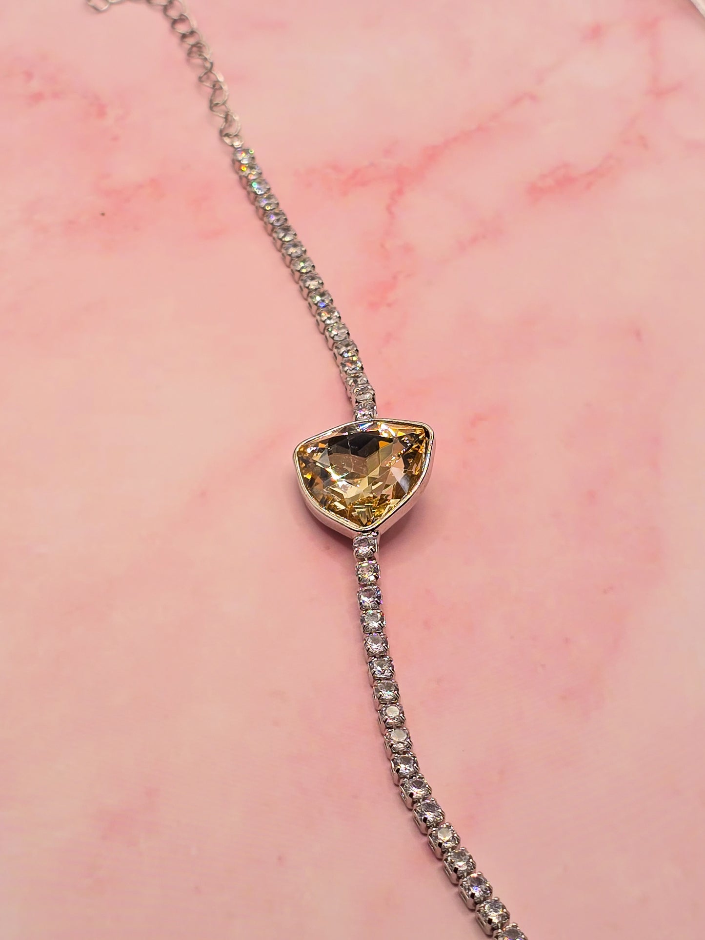 Elegant silver bracelet with a heart-shaped yellow gemstone and sparkling crystal accents.