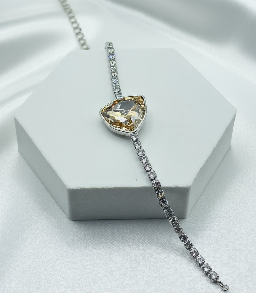 Elegant silver bracelet with a heart-shaped yellow crystal and sparkling clear stones.