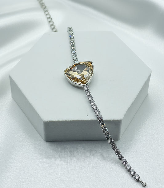 Elegant silver bracelet with a heart-shaped yellow crystal and sparkling clear stones.