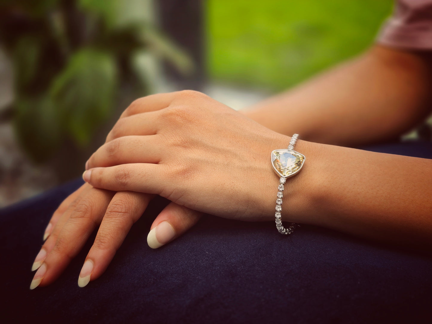 Elegant silver bracelet with large triangular crystal and smaller stone accents, perfect for any occasion.