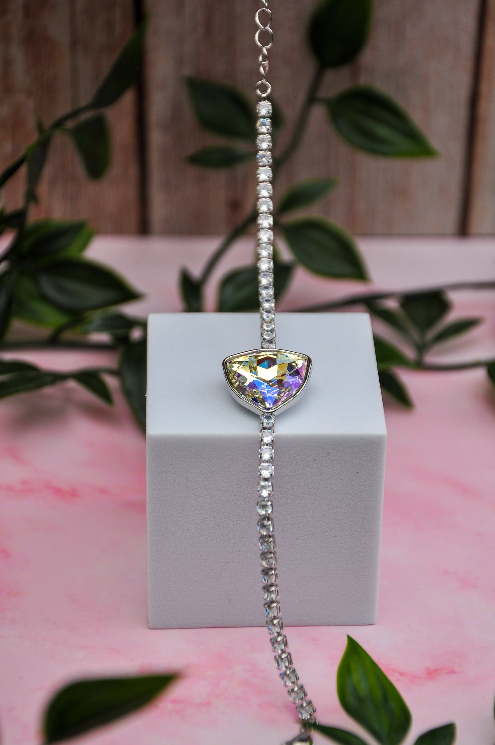 Sparkling silver bracelet with rainbow triangle gem and crystal accents, perfect for elegant occasions.