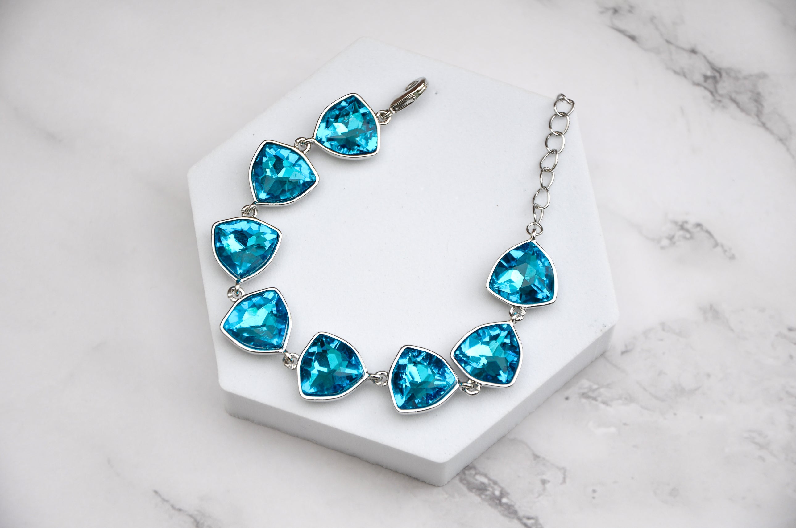 Turquoise gemstone bracelet with silver chain, featuring multiple triangular faceted stones.