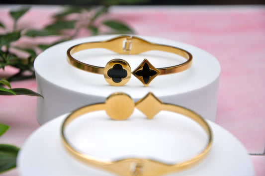 Elegant gold cuff bracelets with black enamel geometric accents, perfect for stylish layering.