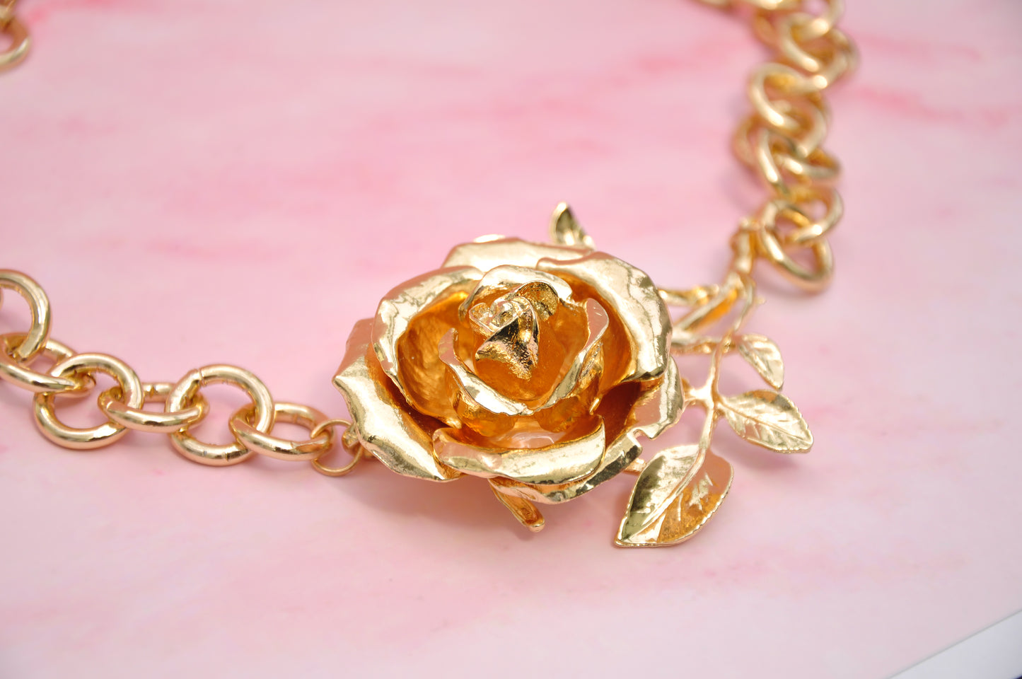 Gold-plated floral necklace featuring a rose pendant and leaf details, perfect for elegant accessorizing.