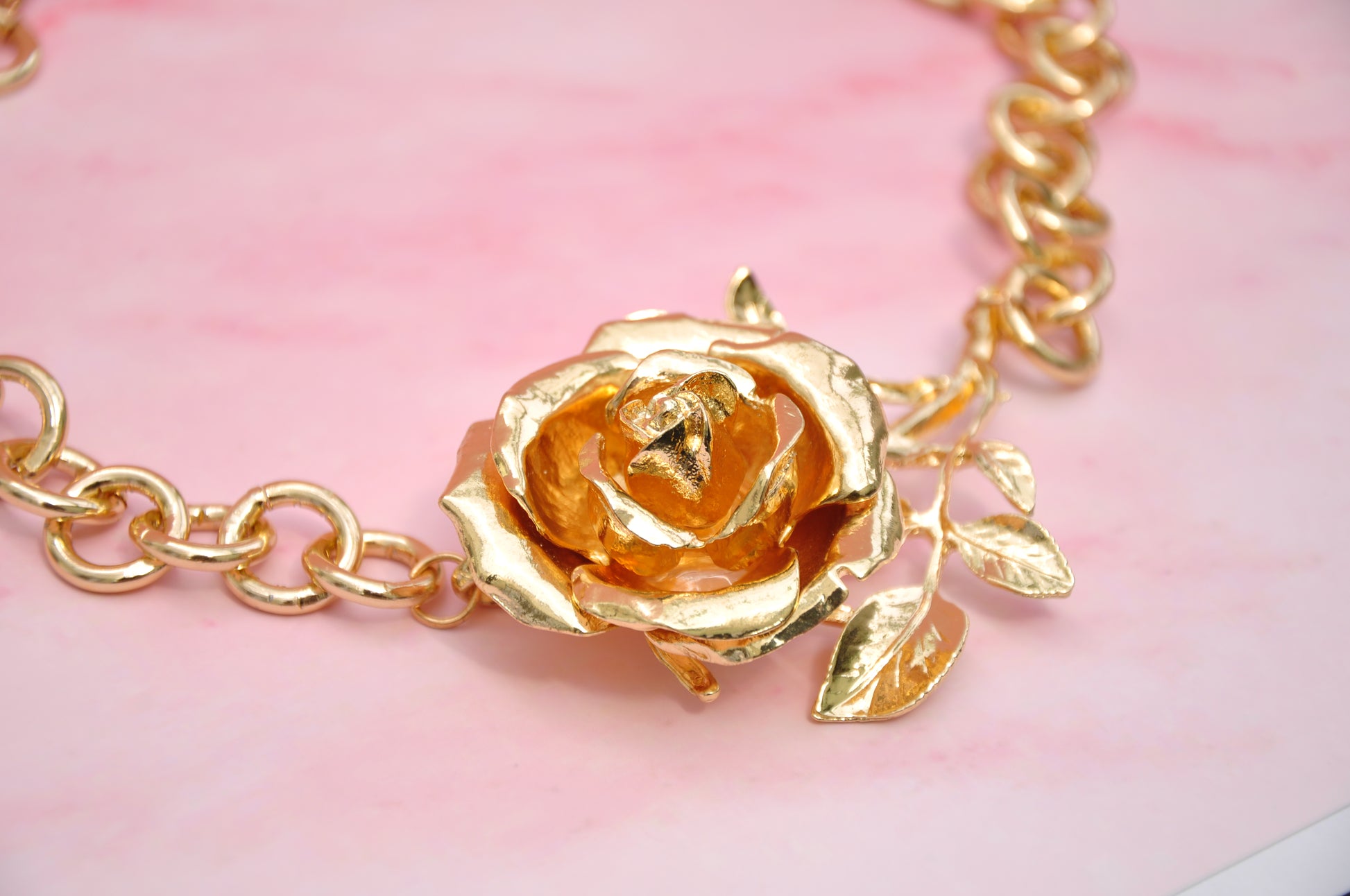 Gold-plated floral necklace featuring a rose pendant and leaf details, perfect for elegant accessorizing.