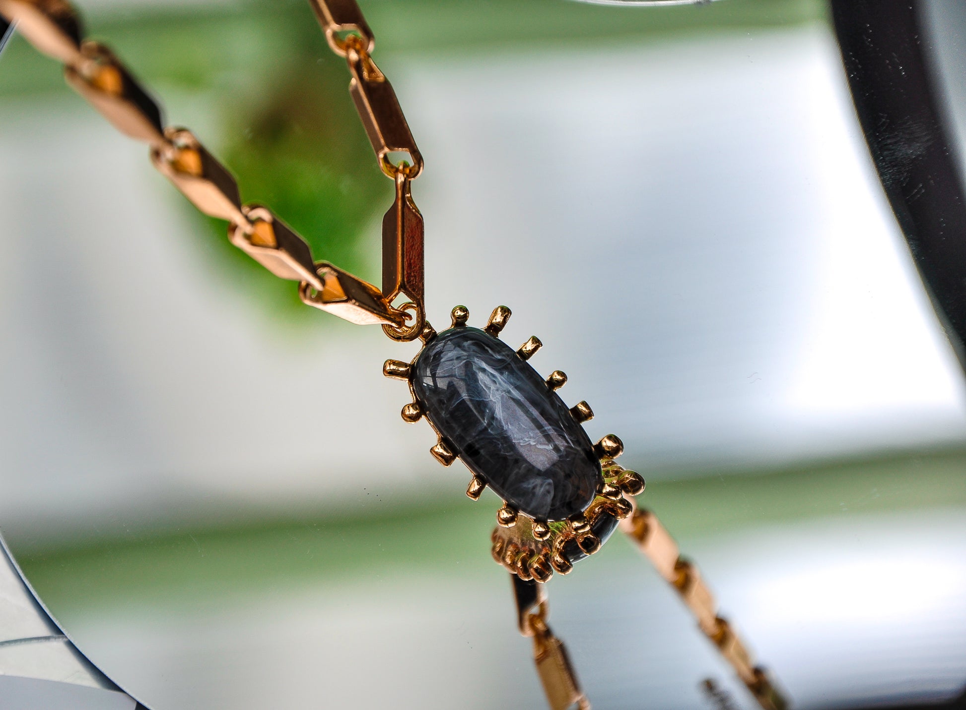 Elegant gold bracelet featuring a prominent black stone centerpiece with intricate detailing.