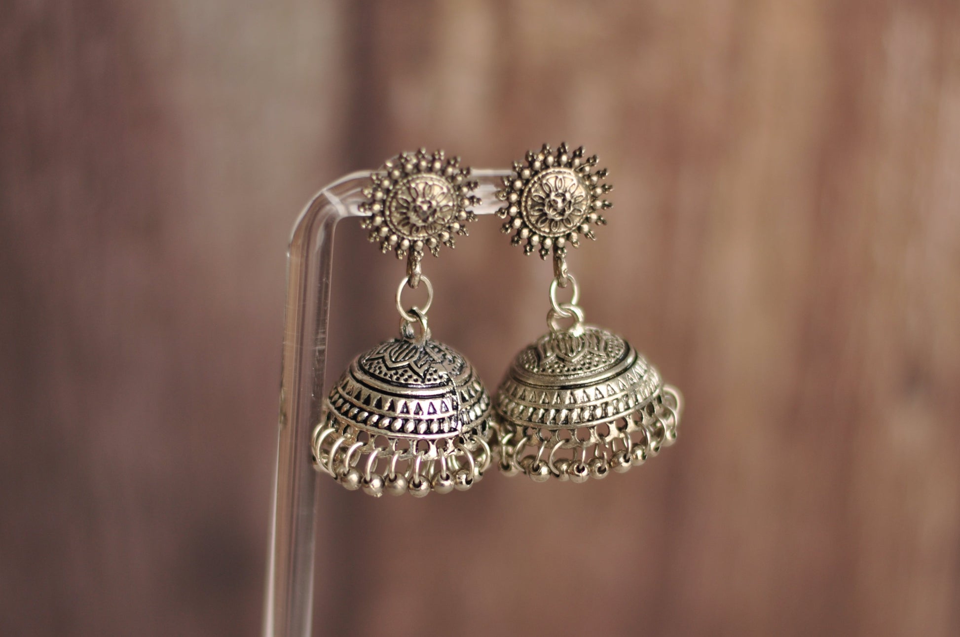 Elegant silver jhumka earrings with intricate detailing and circular stud design, perfect for festive occasions.
