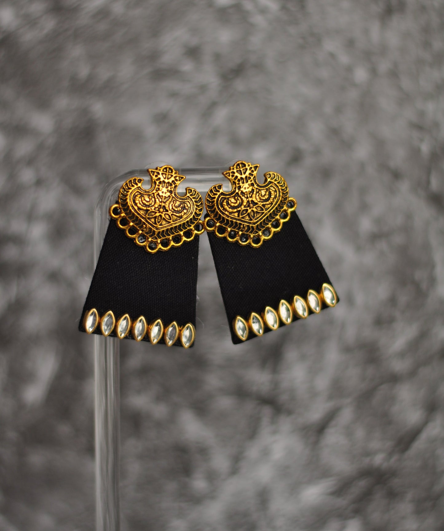 Statement earrings with gold filigree design and black fabric, featuring sparkling rhinestones.