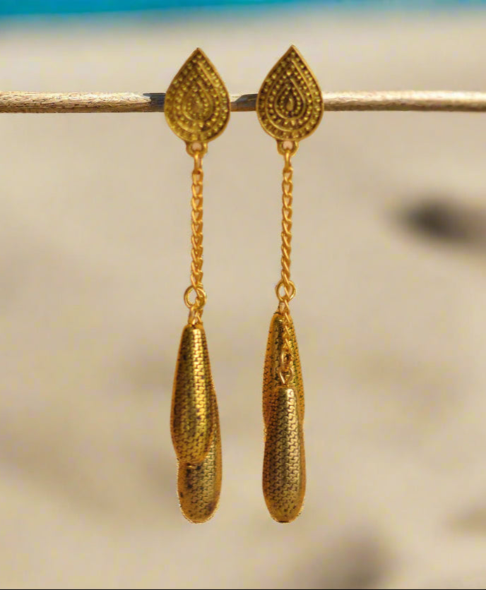 Gold drop earrings with intricate design and chain detail, perfect for elegant outfits.