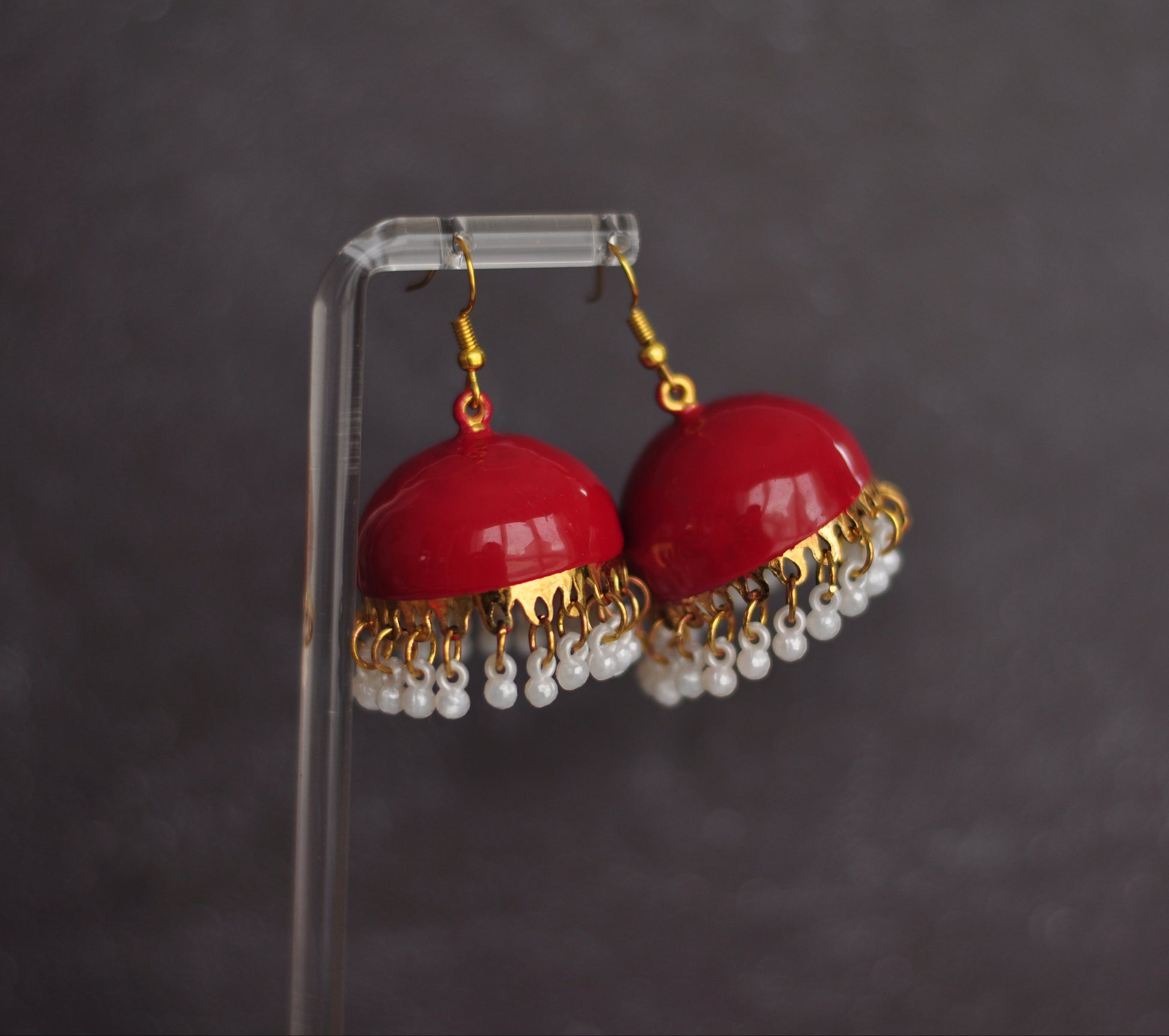 Red dome-shaped earrings with gold accents and white bead fringe, perfect for adding a pop of color.