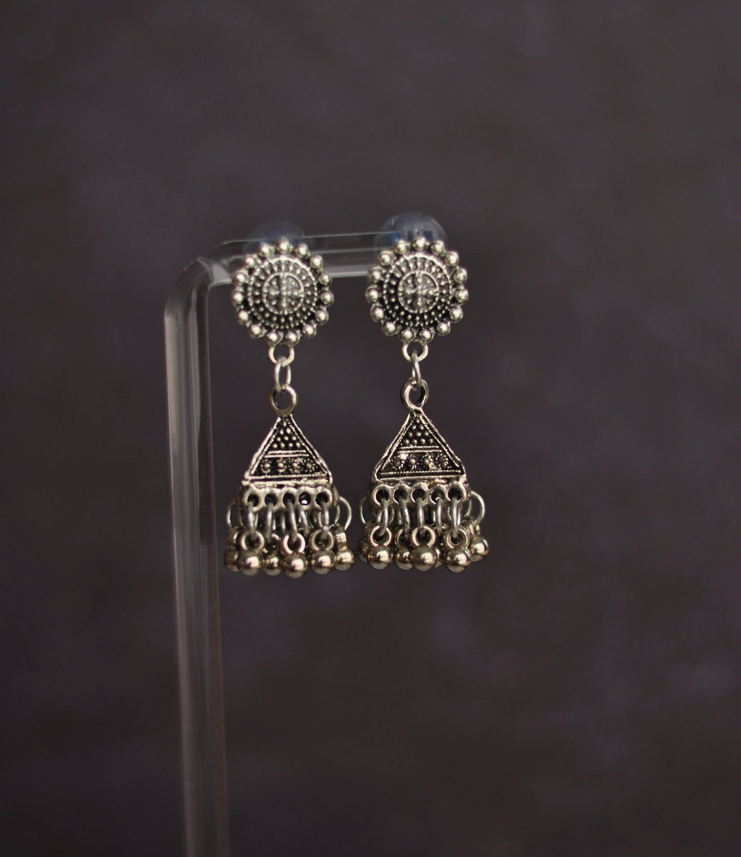 Silver tribal dangle earrings with intricate designs and beaded fringe detailing.