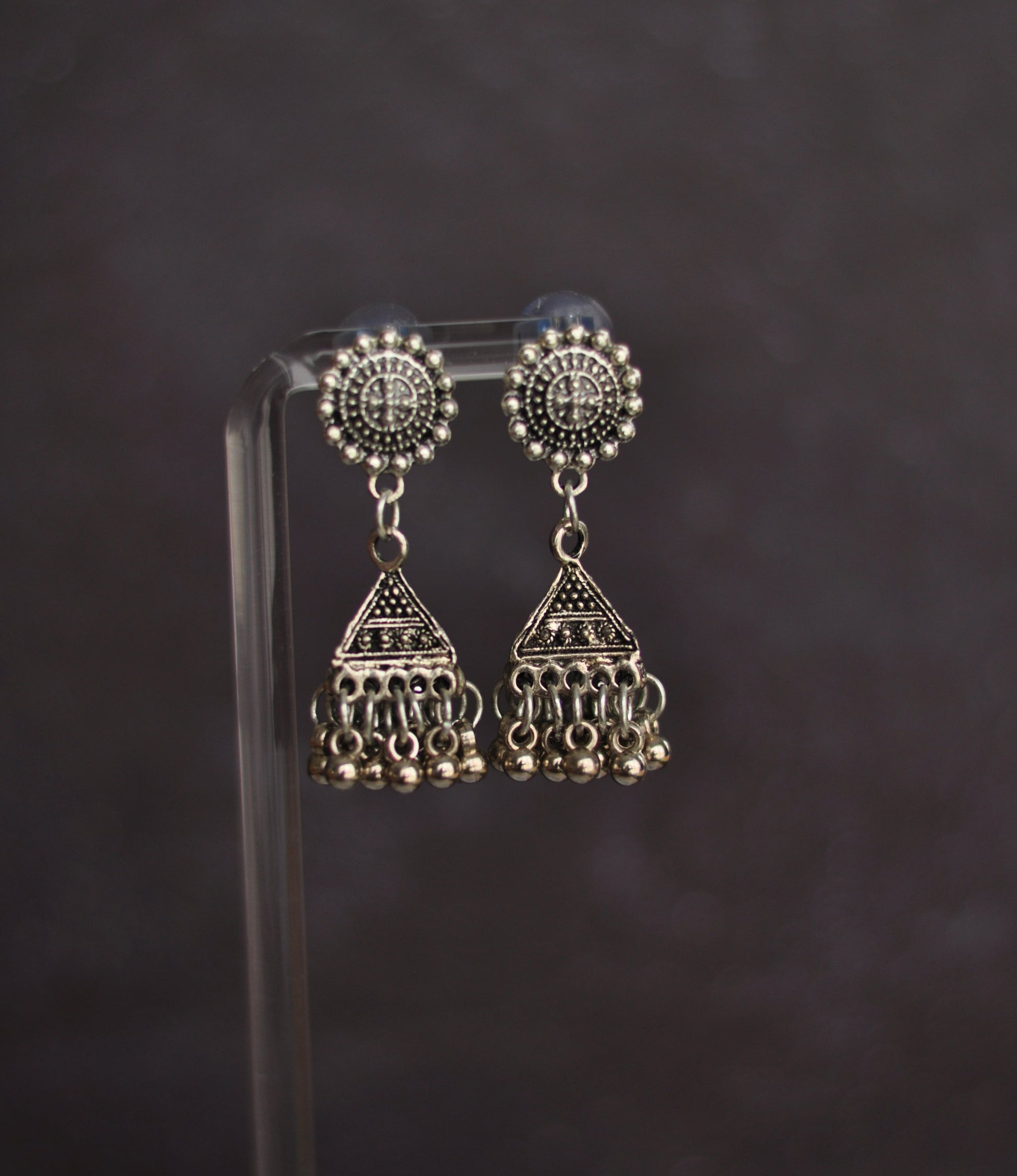Silver tribal dangle earrings with intricate designs and beaded fringe detailing.