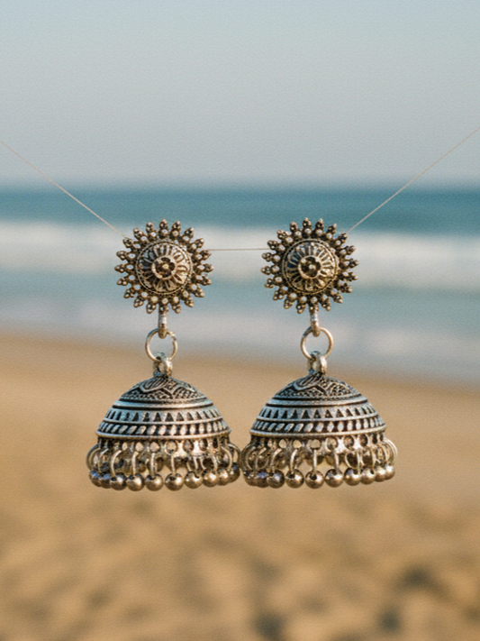 Handcrafted silver jhumka earrings with intricate designs, perfect for bohemian or traditional styles.