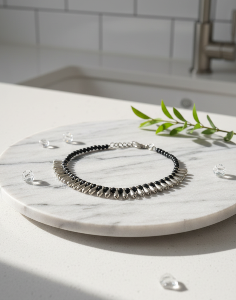 Elegantly crafted black and silver beaded bracelet on marble surface, highlighting its unique design.