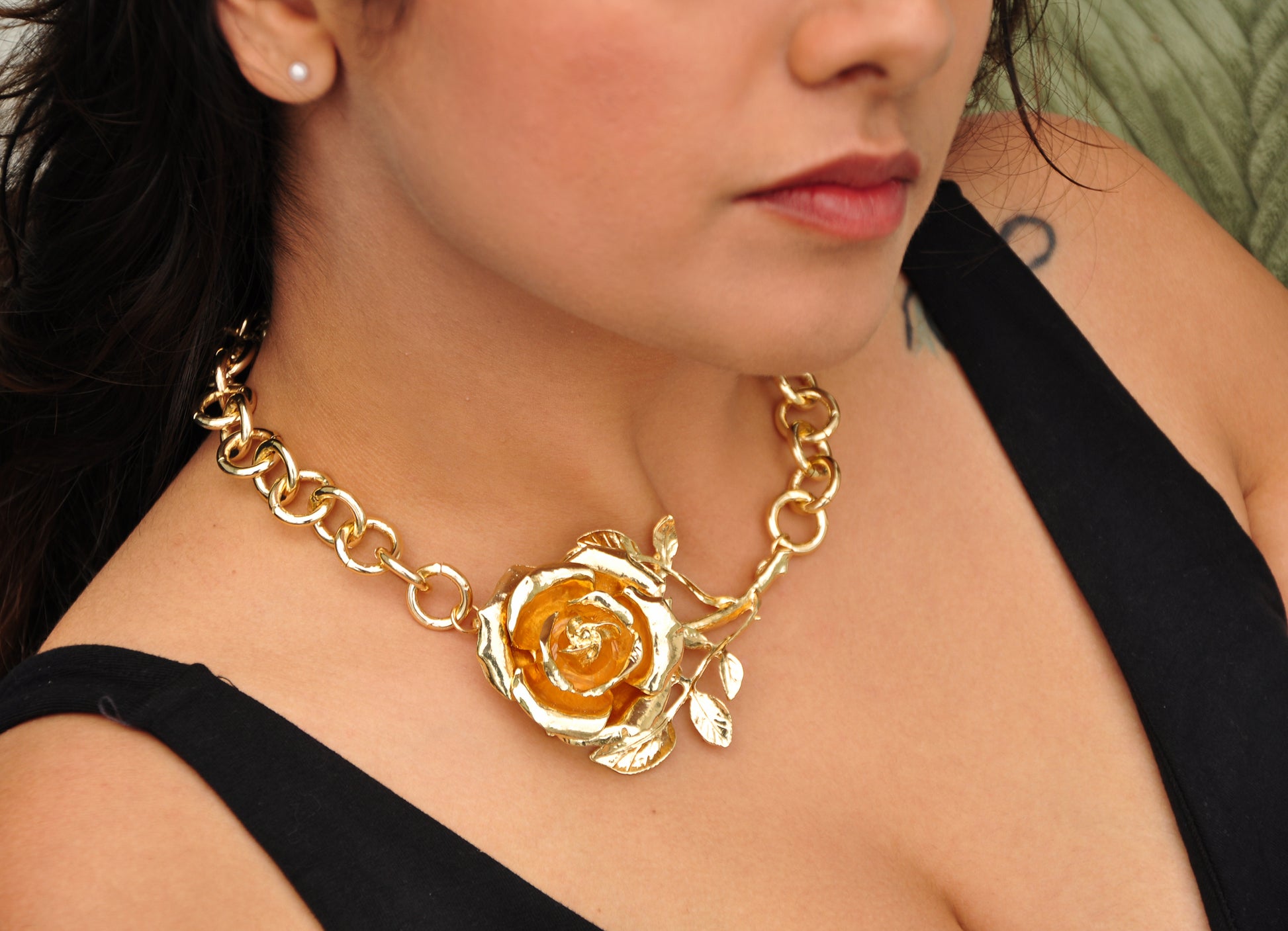 Elegant gold necklace featuring a rose design, crafted from metal, perfect for upscale fashion looks.