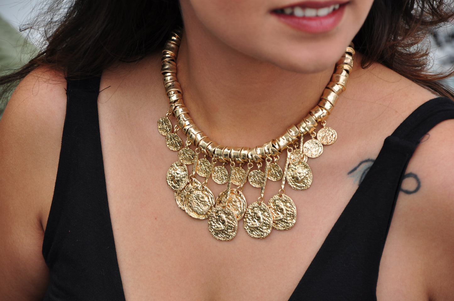 Gold statement necklace with coin pendants, featuring adjustable design for a stylish look.