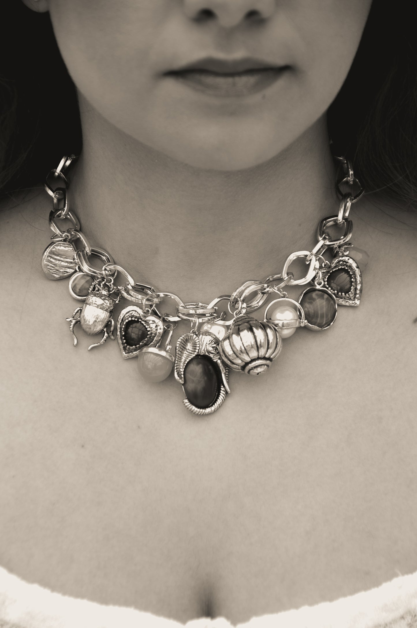 Chunky silver charm necklace featuring various colorful stones and intricate designs, perfect for stylish outfits.