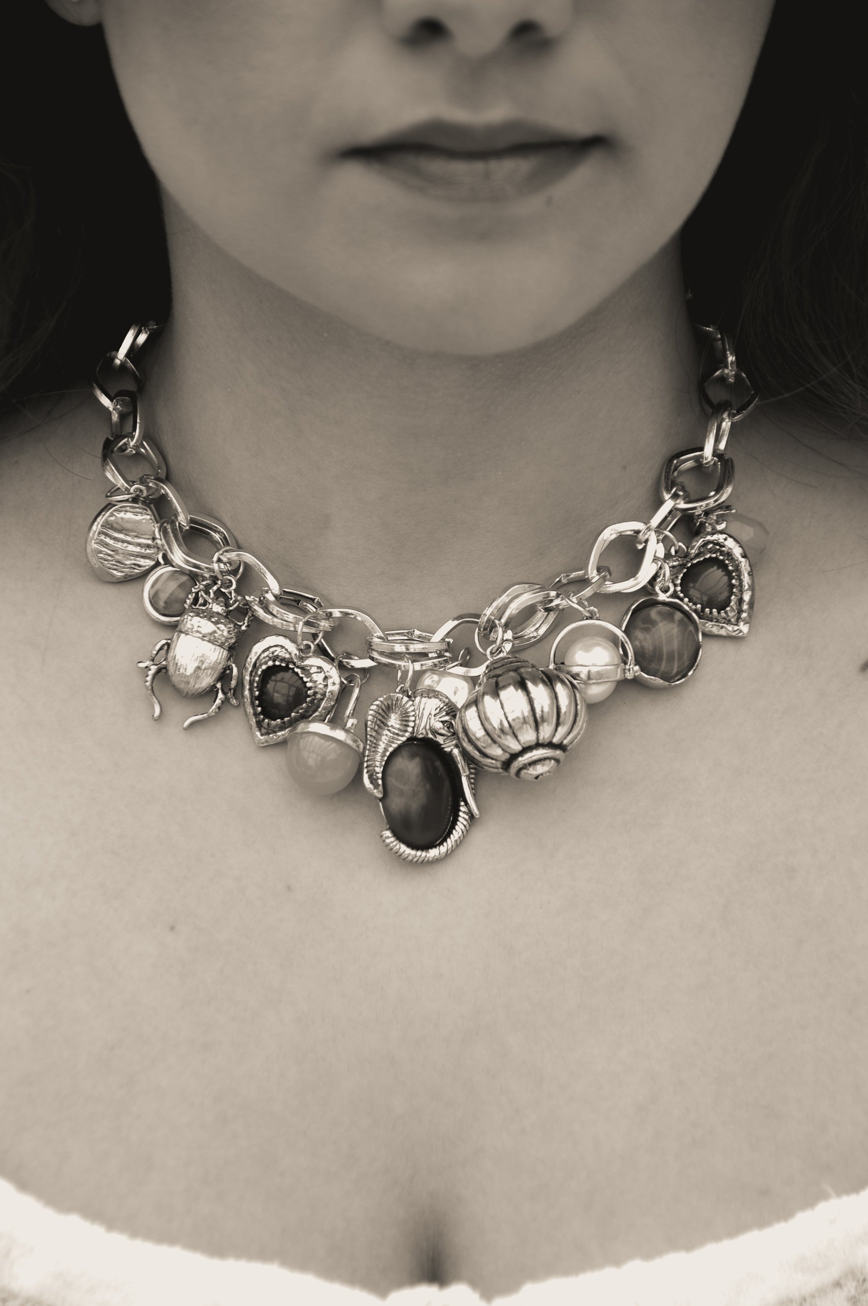 Chunky silver charm necklace featuring various colorful stones and intricate designs, perfect for stylish outfits.
