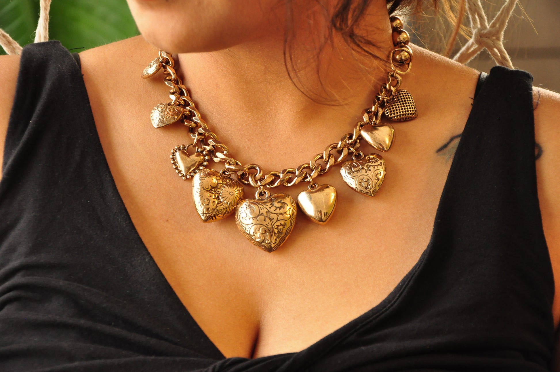 Gold heart charm necklace with intricate designs, perfect for adding elegance to any outfit.