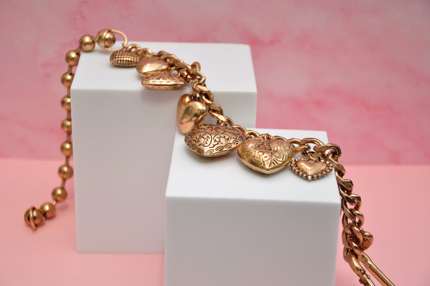 Charming gold heart charm bracelet with intricate designs, perfect for adding elegance to any outfit.