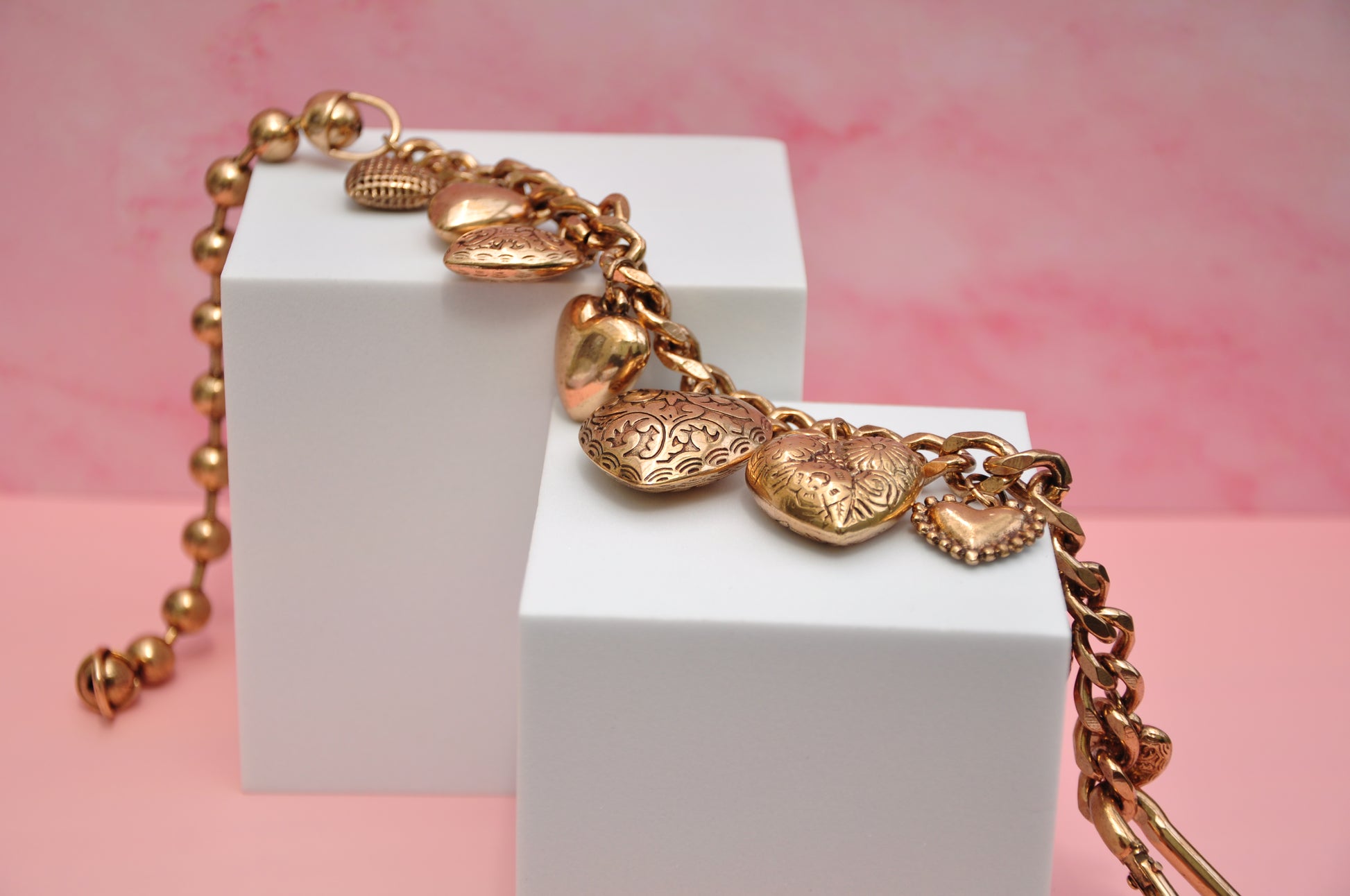 Charming gold heart charm bracelet with intricate designs, perfect for adding elegance to any outfit.