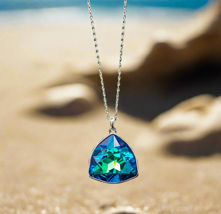 Triangular blue-green crystal pendant necklace on a silver chain, perfect for beach-themed jewelry.