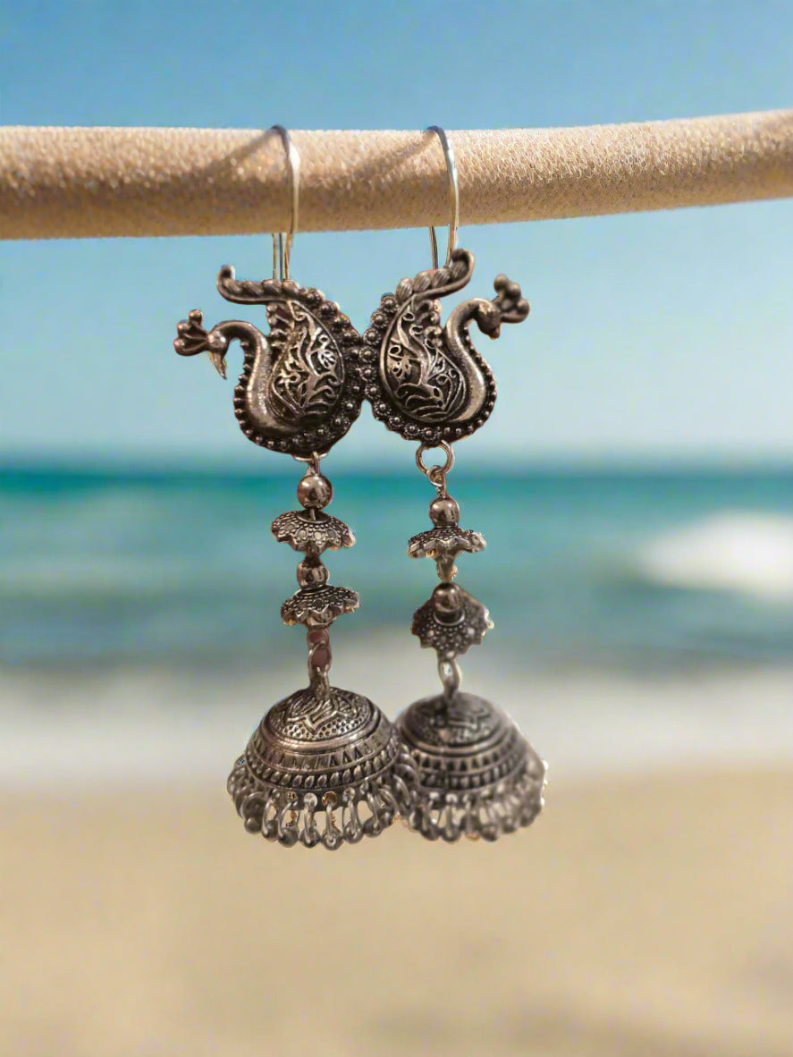 Silver peacock earrings with intricate designs and dangle bells, perfect for vibrant boho styles.