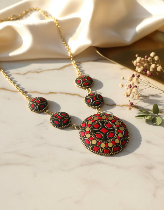 Elegant red and black statement necklace with intricate patterns and gold accents.