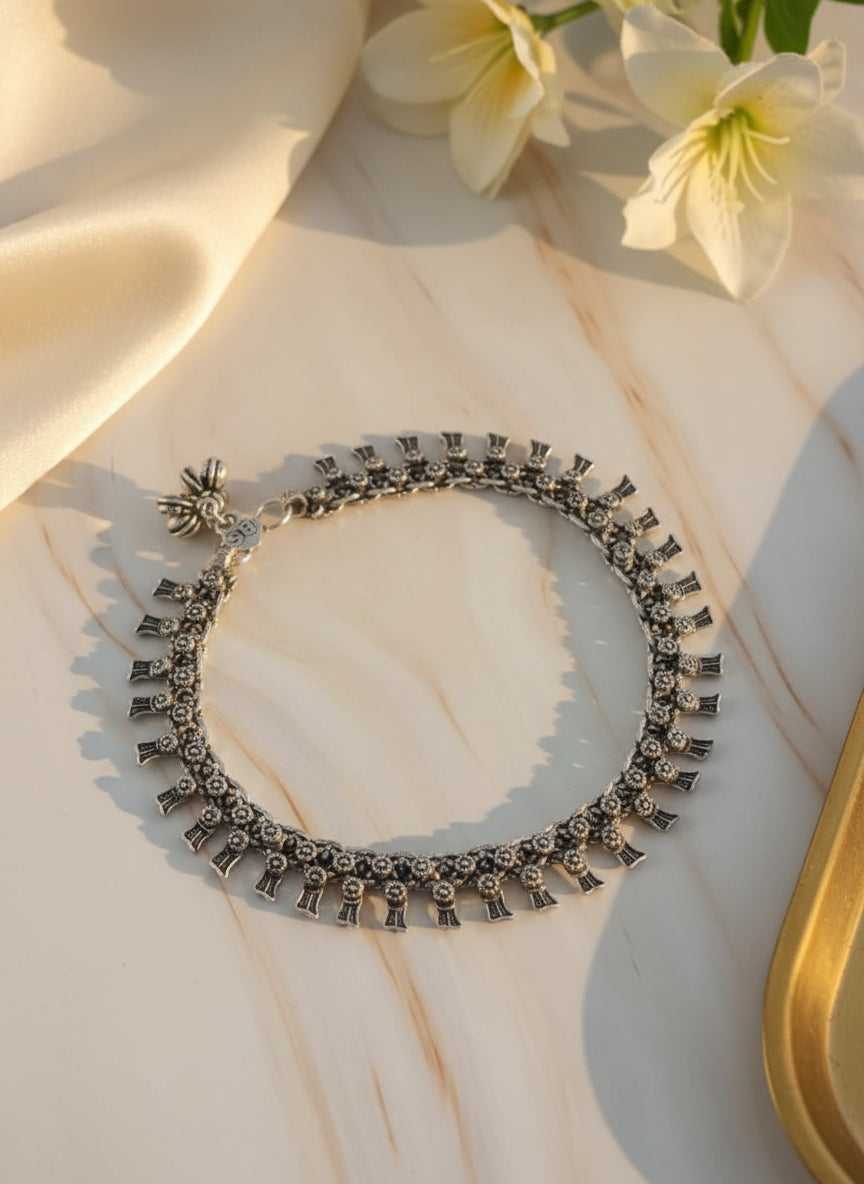 Silver statement necklace with intricate details and floral charm, perfect for elegant occasions.