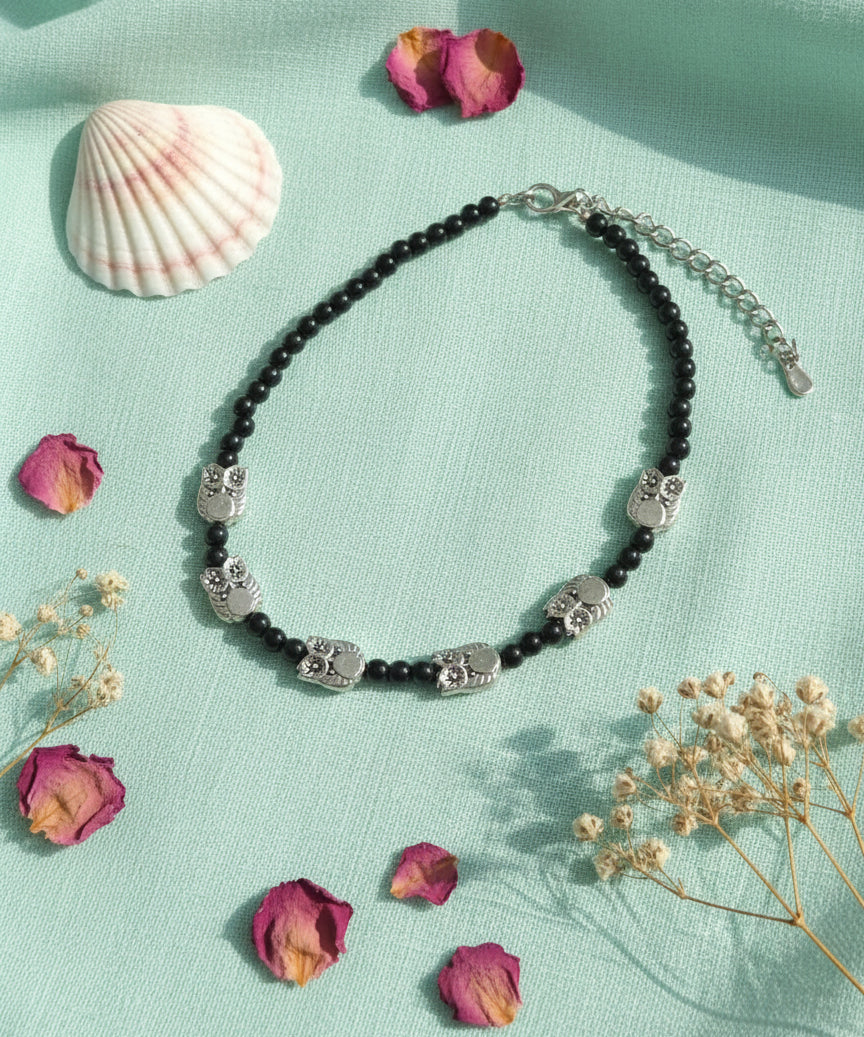 Black beaded necklace with silver owl charms, perfect for boho-chic style and unique accessories.
