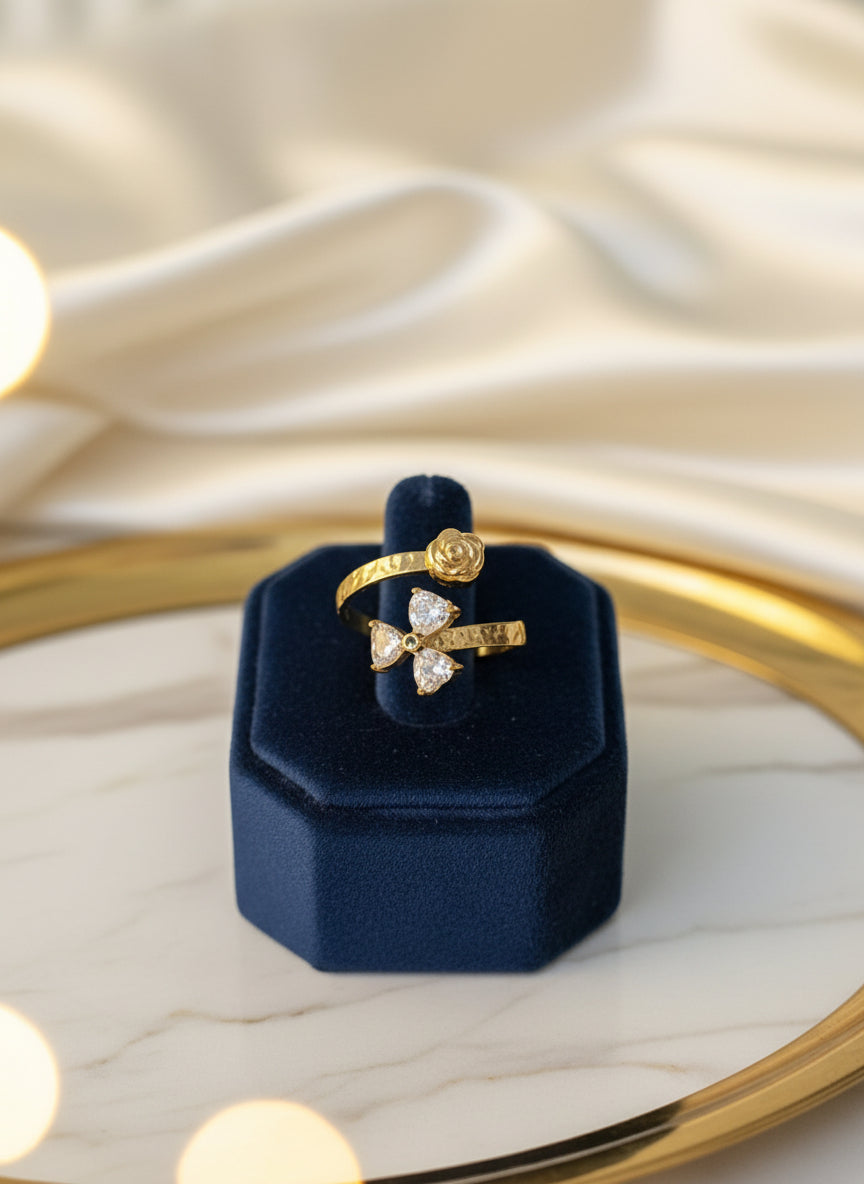 Elegant gold ring with rose and pear-shaped diamonds, displayed on a blue velvet stand.