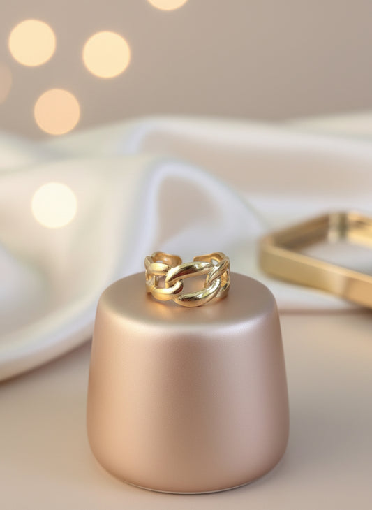 Elegant gold chain link ring displayed on a soft pink pedestal, perfect for stylish accessorizing.