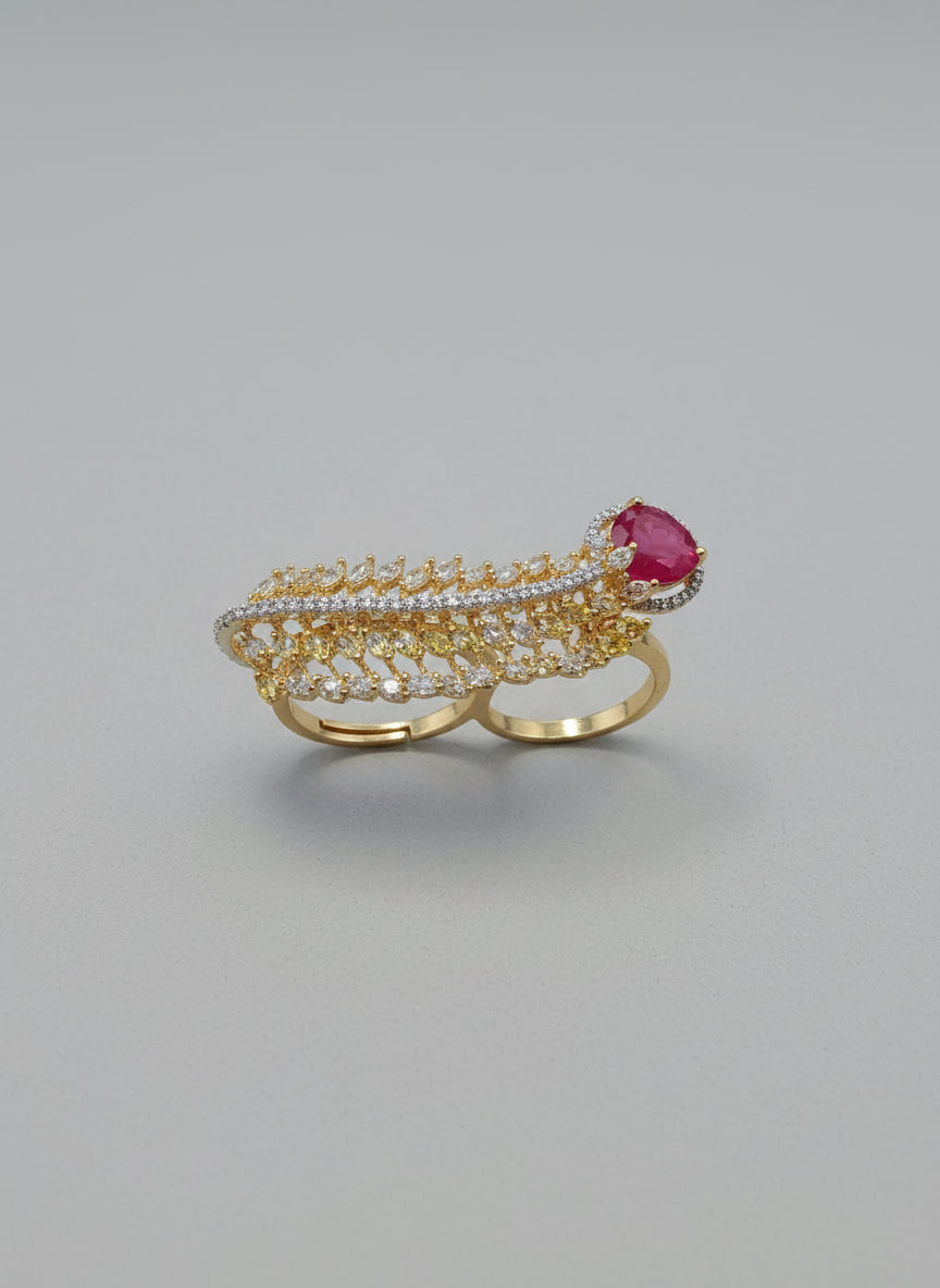 Elegant gold ring with intricate leaf design, encrusted with diamonds and featuring a central ruby.