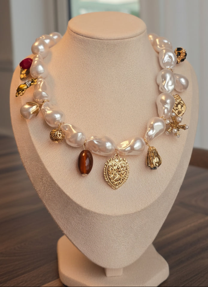 Elegant pearl necklace with golden charms and unique gemstones, perfect for special occasions.