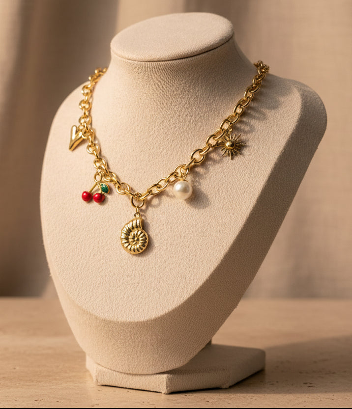 Gold chain necklace with shell, pearl, and cherry charm accents, perfect for summer vibes.