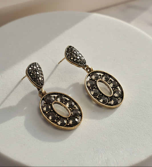 Elegant gold and black earrings with oval design and sparkly rhinestones, perfect for special occasions.