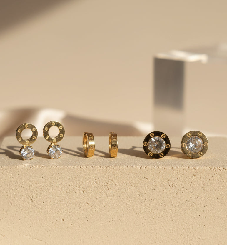 Elegant gold earrings set with clear crystals, featuring hoop and stud designs for versatile styles.