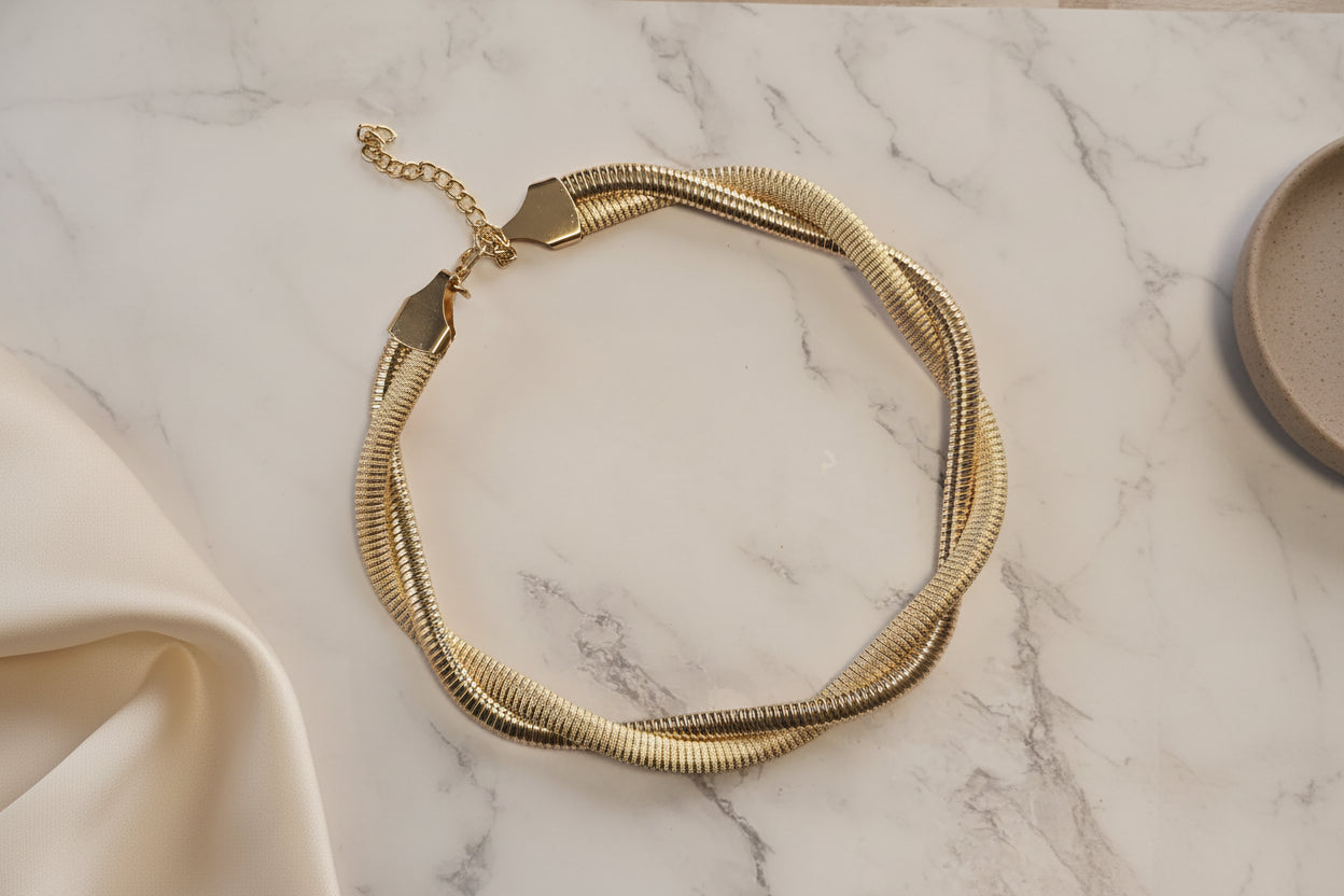 Twisted gold metal necklace with clasp, elegant design, perfect for any occasion.
