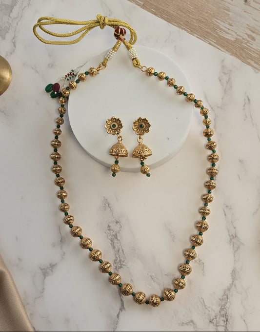 Gold tone necklace with green beads and matching earrings, perfect for traditional occasions.