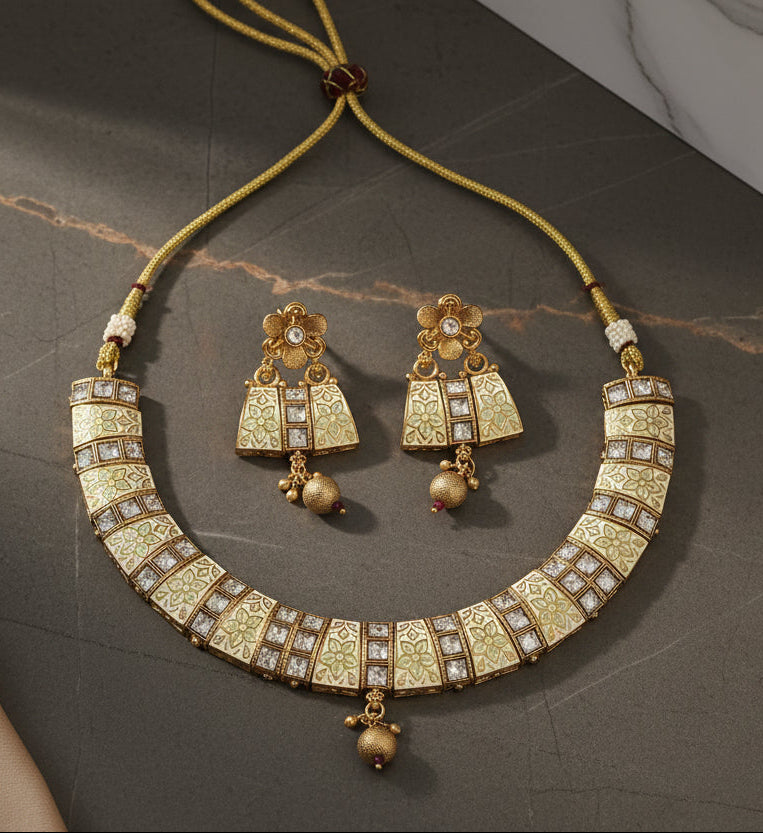 Elegant gold-plated necklace and earring set with floral patterns and gemstones.