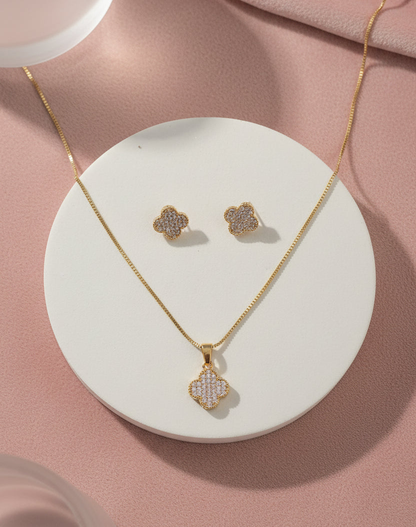 Gold jewelry set featuring a flower pendant necklace and matching stud earrings, embellished with crystals.