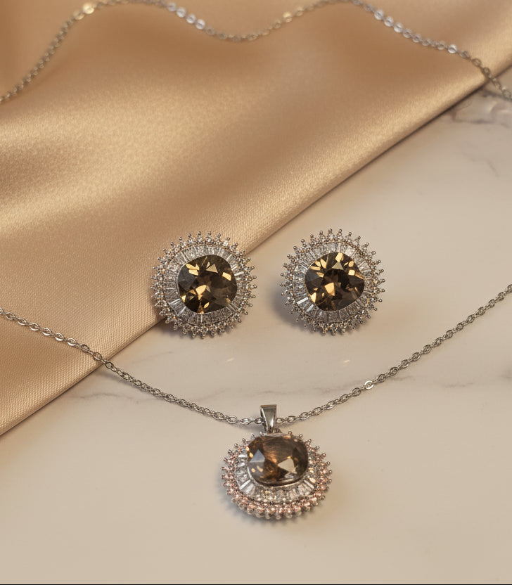 Elegant jewelry set featuring a silver necklace and matching earrings with smoky brown gemstones.
