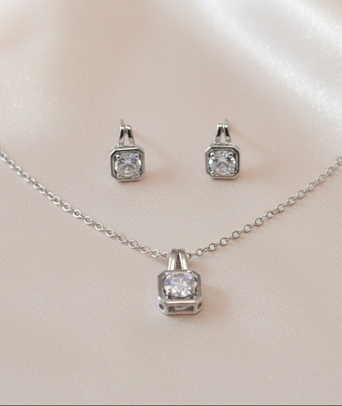Elegant silver jewelry set featuring a necklace and matching earrings with sparkling cubic zirconia stones.