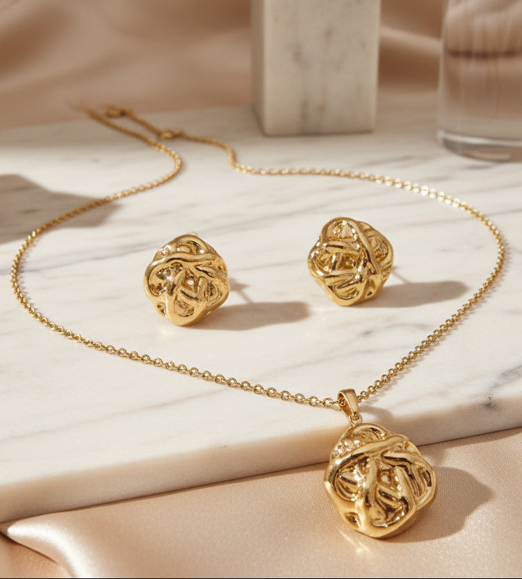 Elegant gold jewelry set featuring a necklace and matching earrings with intricate knot designs.